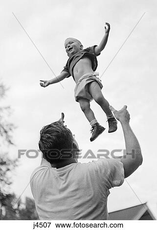 1950S 1960S Father Tossing His Son Up Into The Air View Large Photo Image Stock Photo - 1950S 1960S Father Tossing His Son Up Into The Air. Fotosearch