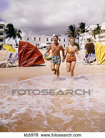 1950s 1960s HAPPY COUPLE ON TROPICAL BEACH FLORIDA USA View Large Photo Image Stock Photo - 1950s 1960s HAPPY COUPLE ON TROPICAL BEACH FLORIDA USA. Fotosearch