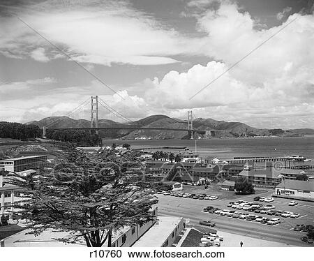 Stock Image - 1950s 1960s PRESIDIO ARMY BASE WITH GOLDEN GATE BRIDGE IN BACKGROUND SAN FRANCISCO CA USA. Fotosearch