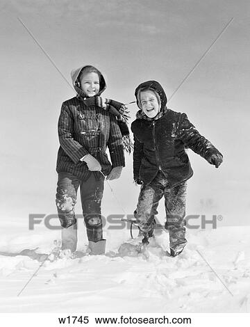 1950s 1960s SMILING BOY GIRL PULLING SLED IN WINTER SNOW View Large Photo Image Stock Photography - 1950s 1960s SMILING BOY GIRL PULLING SLED IN WINTER SNOW. Fotosearch