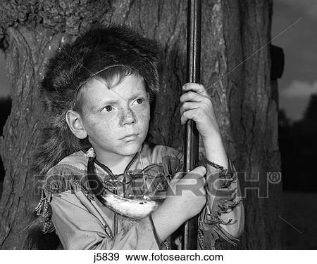 1950S Boy Wearing Raccoon Skin Hat Fringed Western Style Jacket With Powder Horn And Antique Rifle View Large Photo Image Stock Photo - 1950S Boy Wearing Raccoon Skin Hat Fringed Western Style Jacket With Powder Horn And Antique Rifle. Fotosearch