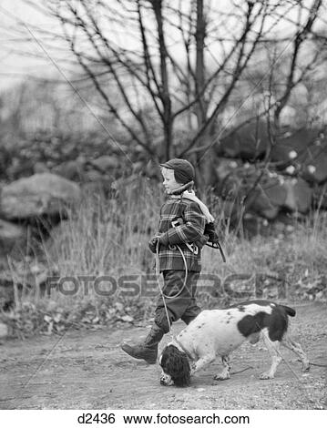 1950s BOY WEARING WINTER COAT HAT SCARF BOOTS ICE SKATES OVER SHOULDER WALKING ENGLISH SPRINGER SPANIEL DOG ON LEASH OUTDOORS View Large Photo Image Stock Photograph - 1950s BOY WEARING WINTER COAT HAT SCARF BOOTS ICE SKATES OVER SHOULDER WALKING ENGLISH SPRINGER SPANIEL DOG ON LEASH OUTDOORS. Fotosearch