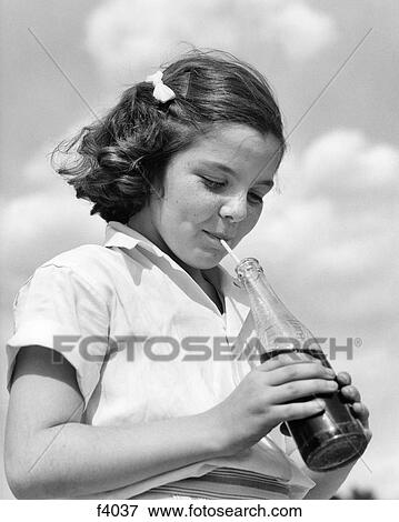 1950s BRUNETTE GIRL DRINKING CARBONATED SODA SOFT DRINK BEVERAGE FROM GLASS BOTTLE WITH A STRAW View Large Photo Image Stock Photo - 1950s BRUNETTE GIRL DRINKING CARBONATED SODA SOFT DRINK BEVERAGE FROM GLASS BOTTLE WITH A STRAW. Fotosearch