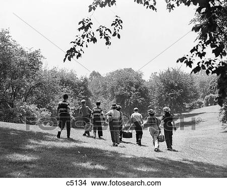 1950S Group Of Eight Teenage Kids Boys Girls Walking In Summer Sunlit Field Carrying Picnic Baskets View Large Photo Image Picture - 1950S Group Of Eight Teenage Kids Boys Girls Walking In Summer Sunlit Field Carrying Picnic Baskets. Fotosearch