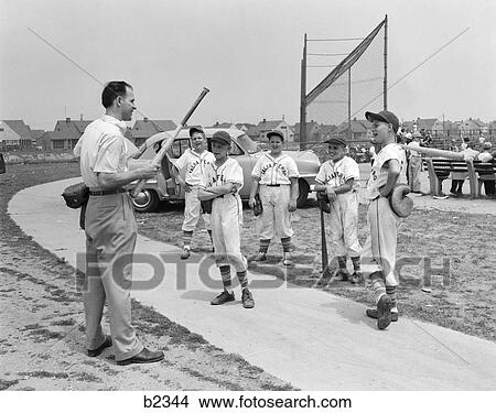 1950S Group Of Little Leaguers Baseball Players Off Of Field Receiving Instructions From Coach Holding Bat & Glove View Large Photo Image Picture - 1950S Group Of Little Leaguers Baseball Players Off Of Field Receiving Instructions From Coach Holding Bat & Glove. Fotosearch