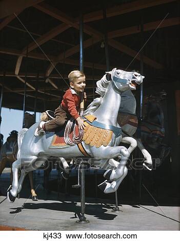 1950s HAPPY SMILING LITTLE BOY RIDING GALLOPING CAROUSEL HORSE ON MERRY GO ROUND View Large Photo Image Stock Image - 1950s HAPPY SMILING LITTLE BOY RIDING GALLOPING CAROUSEL HORSE ON MERRY GO ROUND. Fotosearch