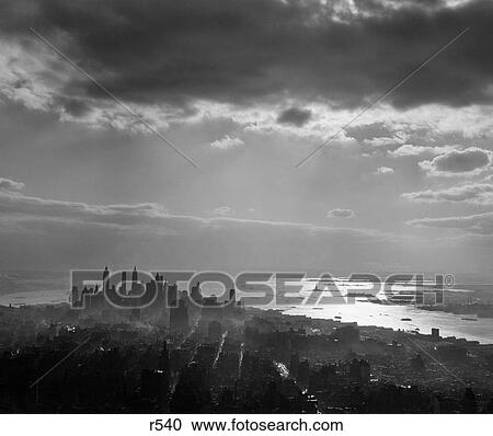 1950S Late Afternoon Light Throws Downtown Manhattan Into Silhouette Sun Reflecting On Bay & Hudson River View Large Photo Image Stock Image - 1950S Late Afternoon Light Throws Downtown Manhattan Into Silhouette Sun Reflecting On Bay & Hudson River . Fotosearch