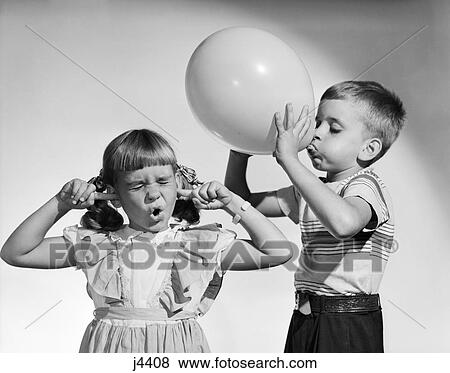 Stock Photo - 1950s LITTLE BOY BLOWING UP BIG BALLOON LITTLE GIRL WITH FINGERS IN EARS EYES CLOSED. Fotosearch