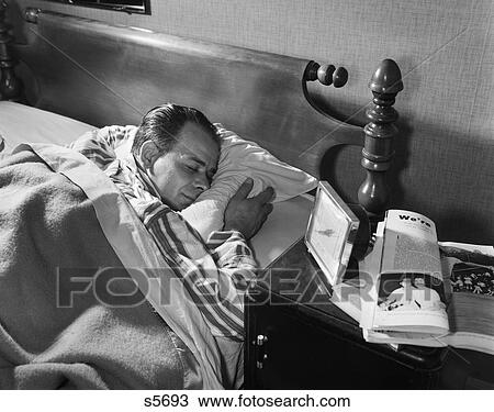 1950S Middle Aged Man Sleeping Asleep Striped Pajamas Clutching A Pillow Night Table Alarm Clock Magazine View Large Photo Image Stock Image - 1950S Middle Aged Man Sleeping Asleep Striped Pajamas Clutching A Pillow Night Table Alarm Clock Magazine. Fotosearch