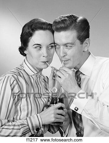 1950S Romantic Couple Head To Head Sharing A Soda Pop Cola One Bottle Two Straws View Large Photo Image Stock Photo - 1950S Romantic Couple Head To Head Sharing A Soda Pop Cola One Bottle Two Straws . Fotosearch