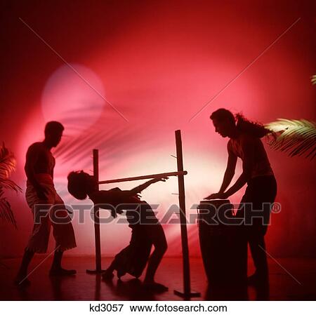 Stock Photo - 1950S Silhouetted Limbo Dancers Woman Going Under Bar Man Playing Conga Drum First Danced At Wakes In Trinidad And Tobago. Fotosearch