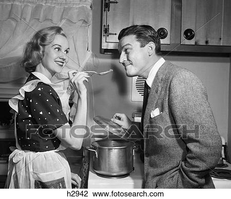 1950S Smiling Housewife At Stove Giving Happy Husband Taste Of Her Cooking View Large Photo Image Stock Image - 1950S Smiling Housewife At Stove Giving Happy Husband Taste Of Her Cooking. Fotosearch