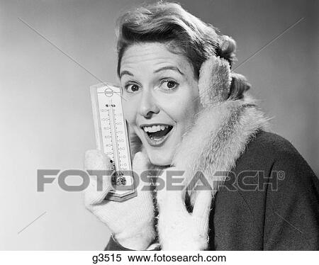 1950S Smiling Woman Looking At Camera In Winter Cold Holding Thermometer Wearing Coat Mittens Earmuffs View Large Photo Image Stock Photography - 1950S Smiling Woman Looking At Camera In Winter Cold Holding Thermometer Wearing Coat Mittens Earmuffs. Fotosearch