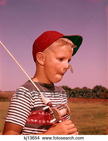 1950s SURPRISED BOY WITH CICADA INSECT ON HIS NOSE HOLDING FISHING POLE WEARING RED BALL CAP View Large Photo Image Picture - 1950s SURPRISED BOY WITH CICADA INSECT ON HIS NOSE HOLDING FISHING POLE WEARING RED BALL CAP. Fotosearch