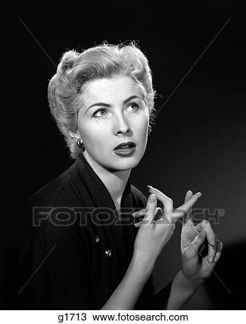 Stock Image - 1950S Thoughtful Blond Woman Counting On Her Fingers Looking Away . Fotosearch