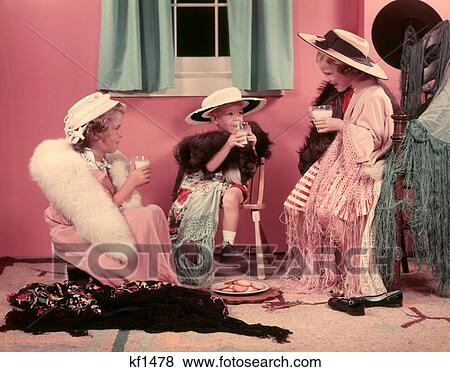 1950s THREE LITTLE GIRLS DRINKING MILK PLAYING ADULT DRESS UP IN OLD CLOTHES AND HATS View Large Photo Image Stock Photo - 1950s THREE LITTLE GIRLS DRINKING MILK PLAYING ADULT DRESS UP IN OLD CLOTHES AND HATS. Fotosearch