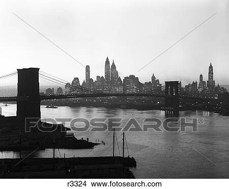 1950S Twilight Skyline Of Lower Manhattan Brooklyn Bridge In Foreground New York Usa View Large Photo Image Picture - 1950S Twilight Skyline Of Lower Manhattan Brooklyn Bridge In Foreground New York Usa. Fotosearch
