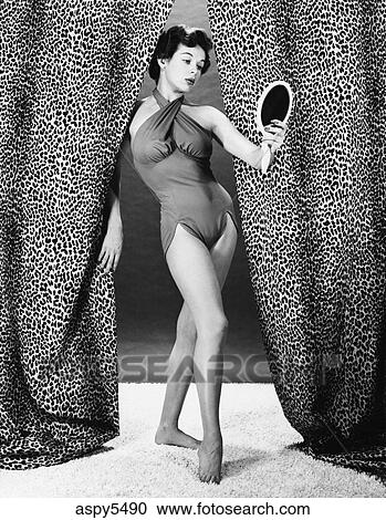 1950s Young Woman Wearing One Piece Bathing Suit Standing Between Leopard Skin Drapes Looking In Mirror Stock Image Aspy5490 Fotosearch