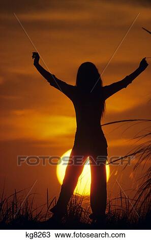 1960s 1970s ANONYMOUS YOUNG WOMAN IN FIELD ARMS RAISED IN TRIUMPH SILHOUETTED AGAINST SETTING SUN View Large Photo Image Stock Image - 1960s 1970s ANONYMOUS YOUNG WOMAN IN FIELD ARMS RAISED IN TRIUMPH SILHOUETTED AGAINST SETTING SUN. Fotosearch