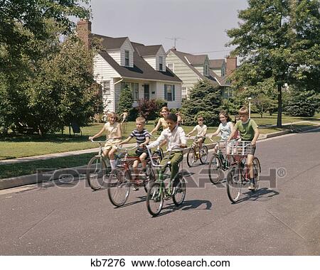 1960s 1970s GROUP OF 7 CHILDREN RIDING BIKES DOWN SUBURBAN STREET View Large Photo Image Stock Photograph - 1960s 1970s GROUP OF 7 CHILDREN RIDING BIKES DOWN SUBURBAN STREET. Fotosearch
