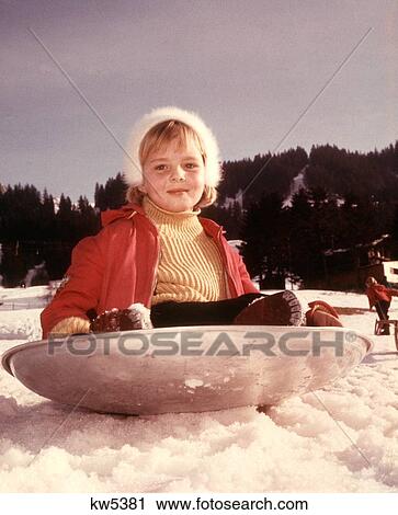 1960S 1970S Smiling Girl Snow Sitting In Silver Aluminum Dish Saucer Sled Looking At Camera Winter Fun Sledding Playing View Large Photo Image Stock Image - 1960S 1970S Smiling Girl Snow Sitting In Silver Aluminum Dish Saucer Sled Looking At Camera Winter Fun Sledding Playing. Fotosearch