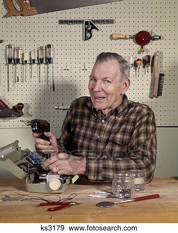 1960s 1970s SMILING SENIOR MAN HOLDING SOLDERING IRON TOOL IN HOME OR GARAGE SHOP LOOKING AT CAMERA View Large Photo Image Stock Photo - 1960s 1970s SMILING SENIOR MAN HOLDING SOLDERING IRON TOOL IN HOME OR GARAGE SHOP LOOKING AT CAMERA. Fotosearch