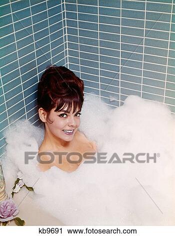 1960'S 1970'S Smiling Woman Sitting In A Bathroom Tub Of Soap Bubbles And Water Taking A Bath Relaxing Indoor Looking At Camera View Large Photo Image Stock Image - 1960'S 1970'S Smiling Woman Sitting In A Bathroom Tub Of Soap Bubbles And Water Taking A Bath Relaxing Indoor Looking At Camera. Fotosearch