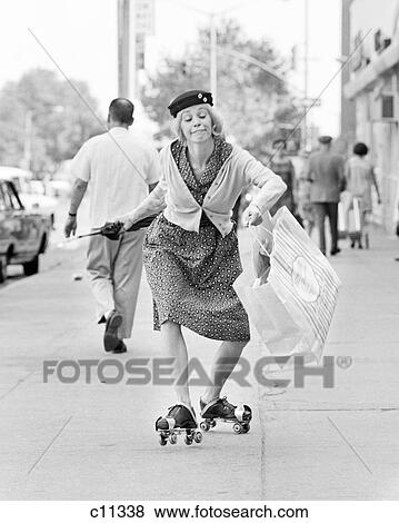 1960s 1970s WOMAN CHARACTER A SHOPPING BAG LADY WITH FUNNY FACIAL EXPRESSION WEARING ROLLER SKATES SKATING ON CITY SIDEWALK View Large Photo Image Stock Photo - 1960s 1970s WOMAN CHARACTER A SHOPPING BAG LADY WITH FUNNY FACIAL EXPRESSION WEARING ROLLER SKATES SKATING ON CITY SIDEWALK. Fotosearch