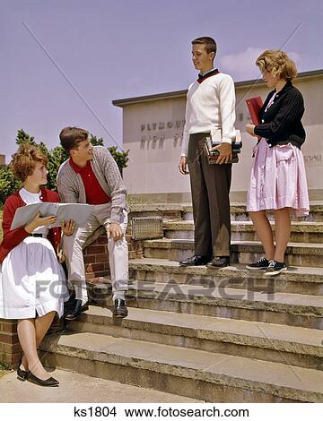 1960s 4 TEENS ON FRONT STEPS HIGH SCHOOL BUILDING TALKING HOLDING BOOKS View Large Photo Image Picture - 1960s 4 TEENS ON FRONT STEPS HIGH SCHOOL BUILDING TALKING HOLDING BOOKS. Fotosearch