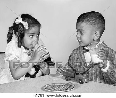 1960s AFRICAN AMERICAN GIRL BOY DRINKING MILK EATING COOKIES View Large Photo Image Stock Image - 1960s AFRICAN AMERICAN GIRL BOY DRINKING MILK EATING COOKIES. Fotosearch