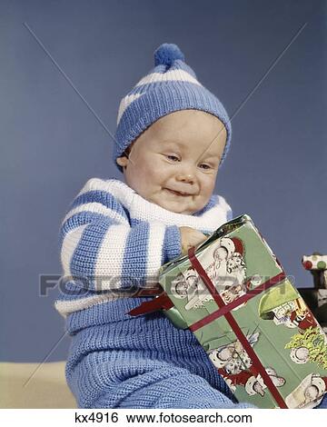 1960s BABY BOY BLUE WHITE KNIT OUTFIT EXCITED OPENING CHRISTMAS PRESENT View Large Photo Image Stock Photograph - 1960s BABY BOY BLUE WHITE KNIT OUTFIT EXCITED OPENING CHRISTMAS PRESENT. Fotosearch
