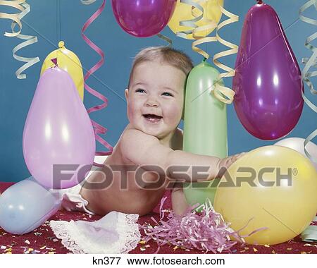 1960s BABY GIRL HUGGING BALLOON CONFETTI STREAMERS SMILING HAPPY View Large Photo Image Stock Photo - 1960s BABY GIRL HUGGING BALLOON CONFETTI STREAMERS SMILING HAPPY. Fotosearch