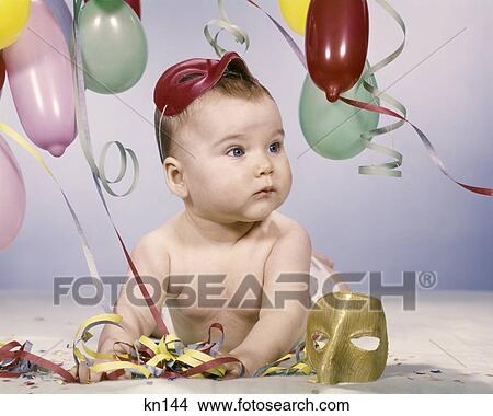 1960s BABY GIRL WITH PARTY BALLOONS STREAMERS AND MASKS View Large Photo Image Picture - 1960s BABY GIRL WITH PARTY BALLOONS STREAMERS AND MASKS. Fotosearch
