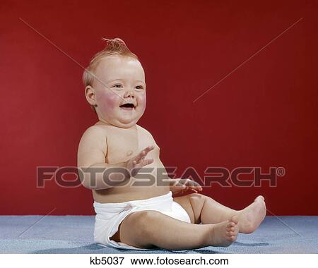 Stock Photo - 1960S BABY WEARING CLOTH DIAPER SITTING UP LAUGHING HAPPY. Fotosearch