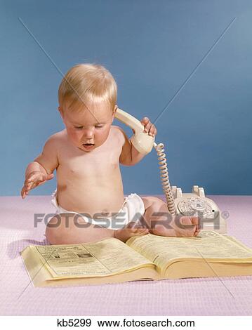 1960s BLOND BABY HOLDING TELEPHONE LOOKING AT PHONEBOOK YELLOW PAGES View Large Photo Image Stock Photo - 1960s BLOND BABY HOLDING TELEPHONE LOOKING AT PHONEBOOK YELLOW PAGES. Fotosearch