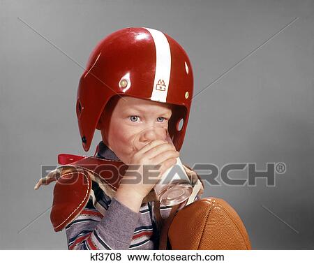 1960s BOY DRINKING GLASS MILK WEARING FOOTBALL HELMET AND SHOULDER PADS View Large Photo Image Stock Photo - 1960s BOY DRINKING GLASS MILK WEARING FOOTBALL HELMET AND SHOULDER PADS. Fotosearch