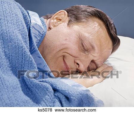 1960s CLOSE UP MAN HEAD ON PILLOW BLUE BLANKET SLEEPING View Large Photo Image Stock Photo - 1960s CLOSE UP MAN HEAD ON PILLOW BLUE BLANKET SLEEPING. Fotosearch