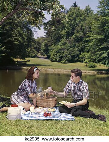1960s COUPLE PICNIC MAN WOMAN FOOD POND PICNICS EAT MEN WOMEN BASKET OUTDOOR OUTSIDE GRASS View Large Photo Image Stock Photography - 1960s COUPLE PICNIC MAN WOMAN FOOD POND PICNICS EAT MEN WOMEN BASKET OUTDOOR OUTSIDE GRASS. Fotosearch