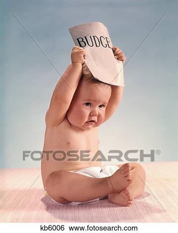 Stock Photograph - 1960s DISTRESSED FRUSTRATED BABY ACTOR SITTING HOLDING BUDGET DOCUMENT OVER HEAD. Fotosearch