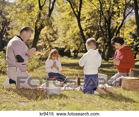 1960s FAMILY KNEELING AROUND PICNIC IN GRASS AUTUMN DAY SAYING GRACE PRAYER View Large Photo Image Stock Photography - 1960s FAMILY KNEELING AROUND PICNIC IN GRASS AUTUMN DAY SAYING GRACE PRAYER. Fotosearch