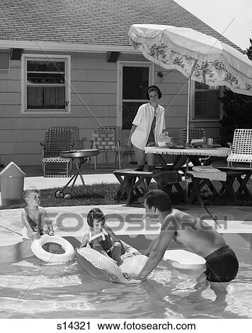 1960s FAMILY OF FOUR AROUND BACKYARD SWIMMING POOL MOTHER AT UMBRELLA TABLE ON PATIO FATHER SON DAUGHTER IN POOL SUMMER View Large Photo Image Stock Image - 1960s FAMILY OF FOUR AROUND BACKYARD SWIMMING POOL MOTHER AT UMBRELLA TABLE ON PATIO FATHER SON DAUGHTER IN POOL SUMMER. Fotosearch