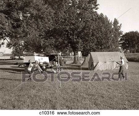 1960s FAMILY VACATION CAMPING IN TENTS BROTHER SISTER PLAYING BADMINTON PARENTS WATCHING FROM LAWN CHAIRS View Large Photo Image Stock Photograph - 1960s FAMILY VACATION CAMPING IN TENTS BROTHER SISTER PLAYING BADMINTON PARENTS WATCHING FROM LAWN CHAIRS. Fotosearch