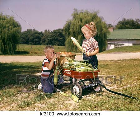 1960s FARM CHILDREN LITTLE BOY GIRL LOADING RED WAGON WITH BASKET OF TOMATOES AND EARS OF CORN View Large Photo Image Stock Image - 1960s FARM CHILDREN LITTLE BOY GIRL LOADING RED WAGON WITH BASKET OF TOMATOES AND EARS OF CORN. Fotosearch