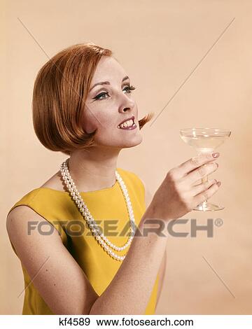1960s FASHIONABLE RED HEADED WOMAN TOASTING HOLDING GLASS OF CHAMPAGNE View Large Photo Image Stock Photo - 1960s FASHIONABLE RED HEADED WOMAN TOASTING HOLDING GLASS OF CHAMPAGNE. Fotosearch