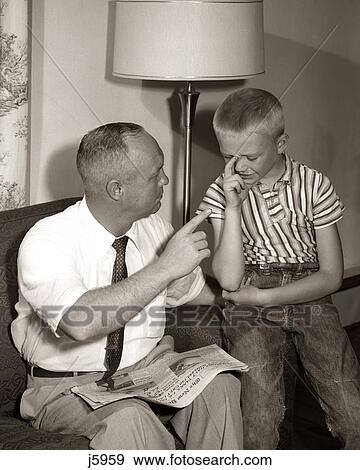 Stock Photo - 1960s FATHER DISCIPLINING UPSET CRYING SON. Fotosearch