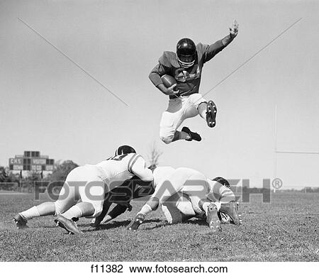 1960S Football Player Jumping Over Blocked Players View Large Photo Image Stock Image - 1960S Football Player Jumping Over Blocked Players. Fotosearch