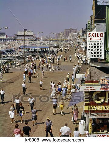 1960s FROM ABOVE LOOKING DOWN AT THE SHORE CROWD OF PEOPLE ON THE BOARDWALK OF BEACH RESORT ATLANTIC CITY NEW JERSEY USA View Large Photo Image Stock Photo - 1960s FROM ABOVE LOOKING DOWN AT THE SHORE CROWD OF PEOPLE ON THE BOARDWALK OF BEACH RESORT ATLANTIC CITY NEW JERSEY USA. Fotosearch