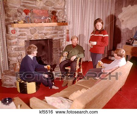 1960s Group Of Men And Women Relaxing By Fireplace Apres Ski Stock