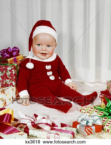 1960s HAPPY BABY WEARING SANTA CLAUS FOOTED PAJAMAS SITTING AMONG WRAPPED CHRISTMAS PRESENTS View Large Photo Image Stock Photo - 1960s HAPPY BABY WEARING SANTA CLAUS FOOTED PAJAMAS SITTING AMONG WRAPPED CHRISTMAS PRESENTS. Fotosearch