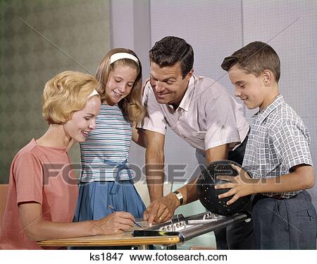 1960s HAPPY FAMILY IN BOWLING ALLEY LOOKING AT SCORE SHEETS BOY HOLDING BALL View Large Photo Image Stock Photo - 1960s HAPPY FAMILY IN BOWLING ALLEY LOOKING AT SCORE SHEETS BOY HOLDING BALL. Fotosearch